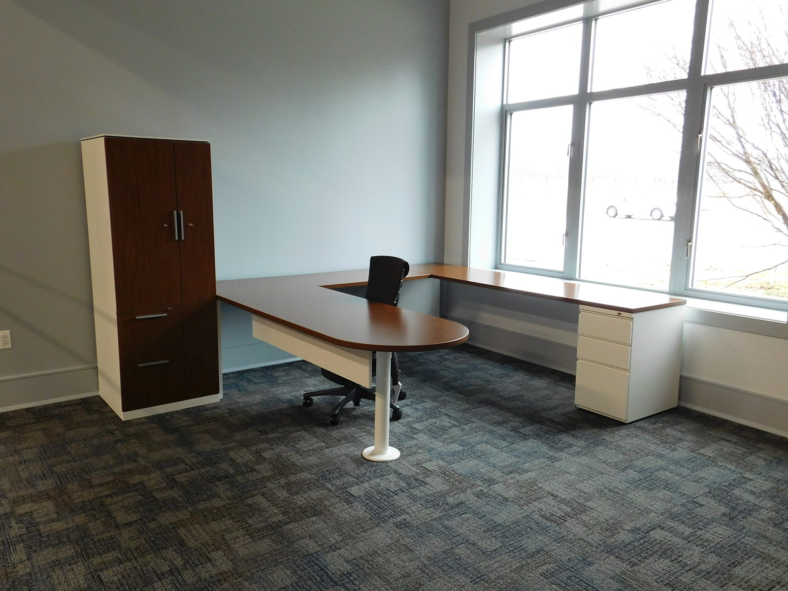 Private office with U-shape desk with wood and white finishes