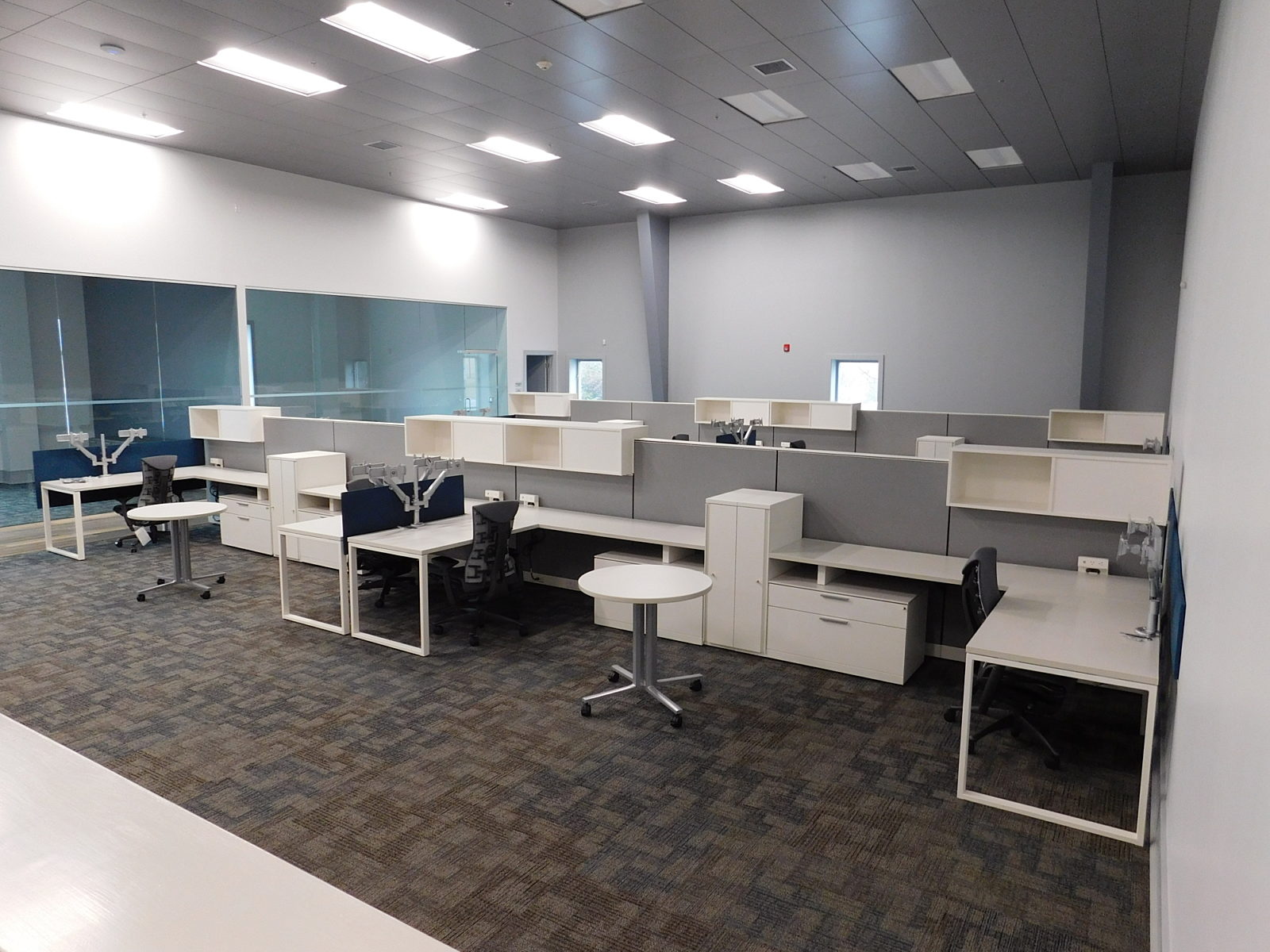 Herman Miller workstations with overhead storage units, personal storage towers and a small round table between stations
