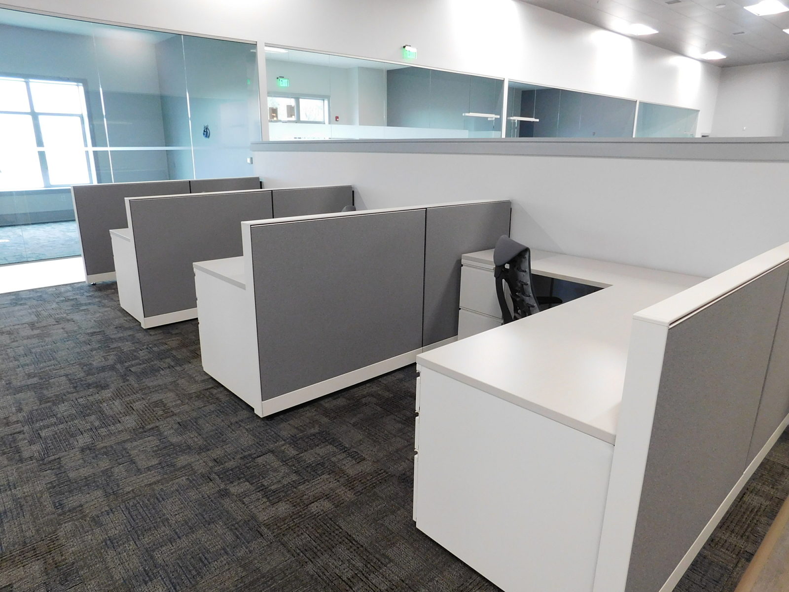 Herman Miller workstations with dark grey fabric panels and white worksurface and storage