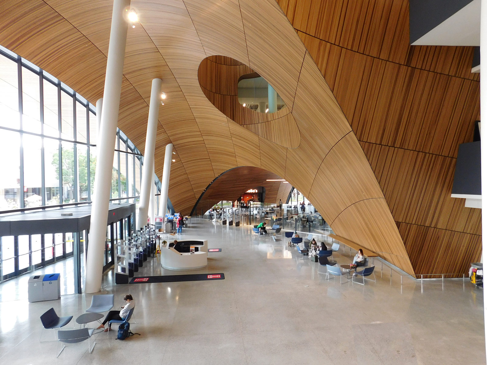 Lobby area of Temple library showing beautiful wooden architectural arches and details. High ceilings and concrete floors with some seating along walls