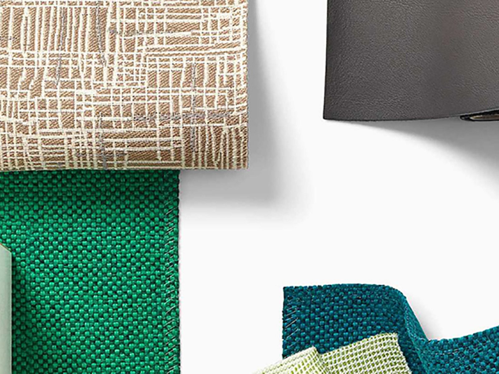 A variety of fabrics and materials are laid out on a white surface.