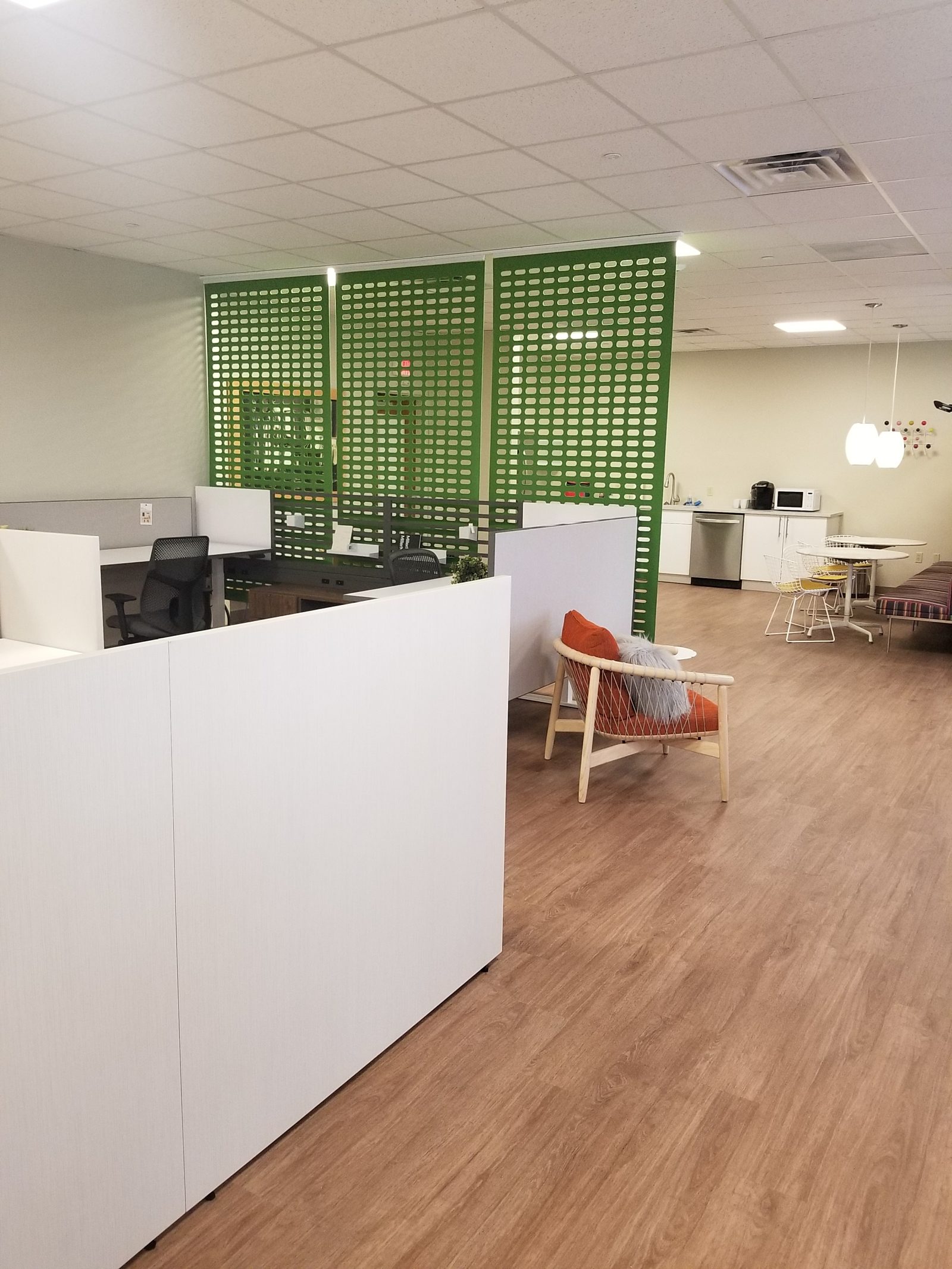 View of the showroom showing white laminate gallery panels, two Knoll Antenna workstations and green acoustical tiles in background.