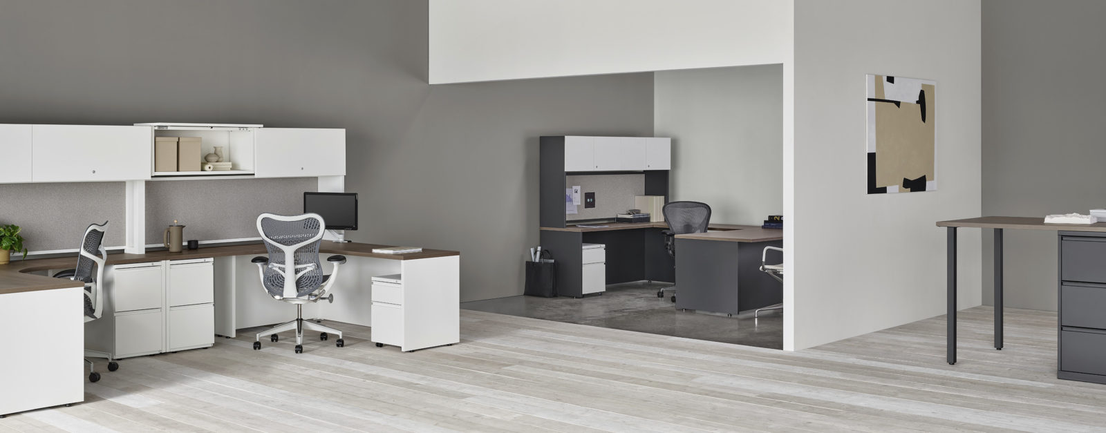 Cluster of 2 Herman Miller workstations in white finish with dark wood tops; U-shape private office in background in black finish with dark wood tops
